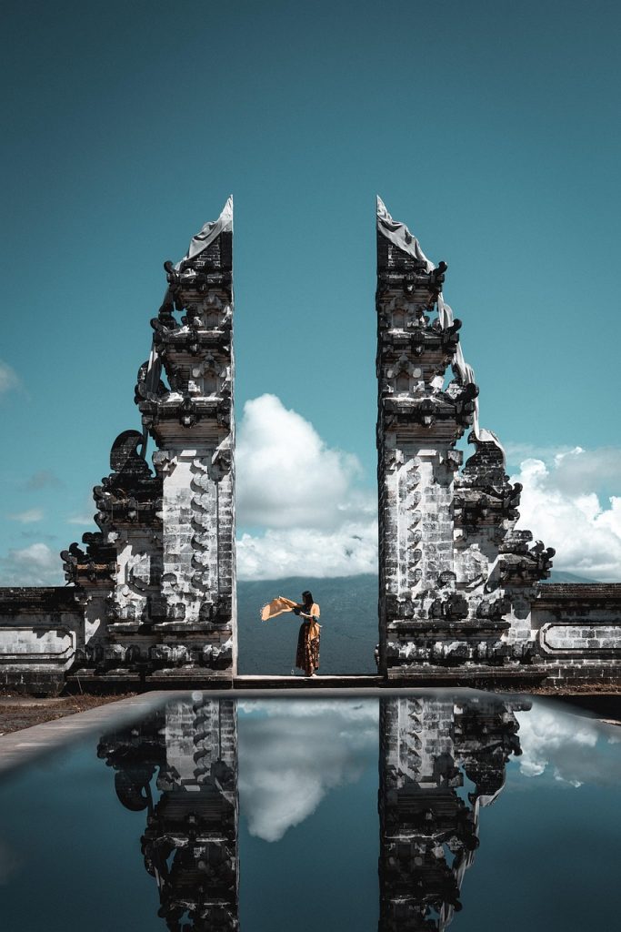 Bali temple gate with mountain views and reflection in a pool